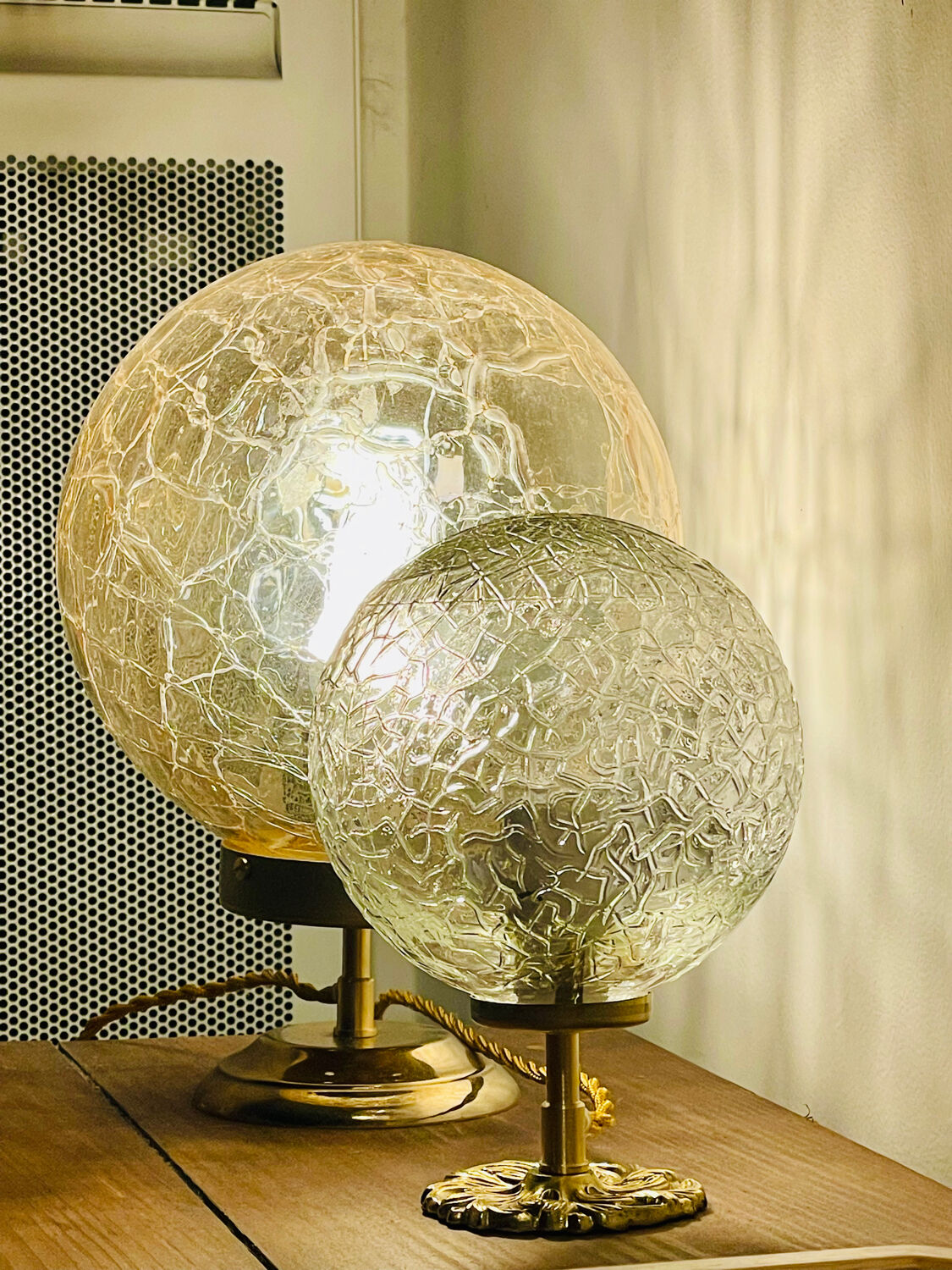 Small handcrafted globe lamp with a cracked finish and a golden brass base.