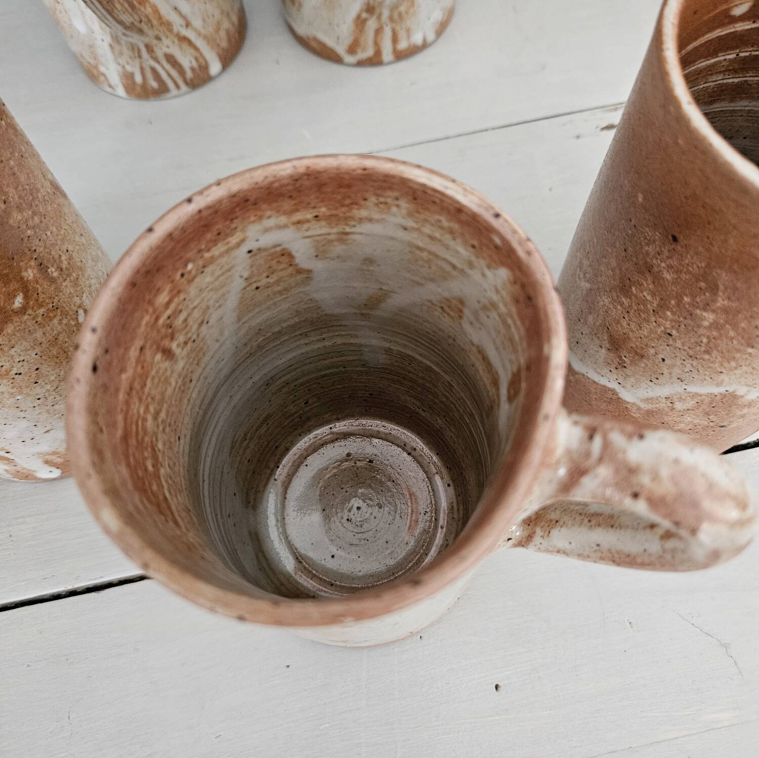 Set of 5 vintage handcrafted stoneware mugs in beige, pink, and white glazed stoneware