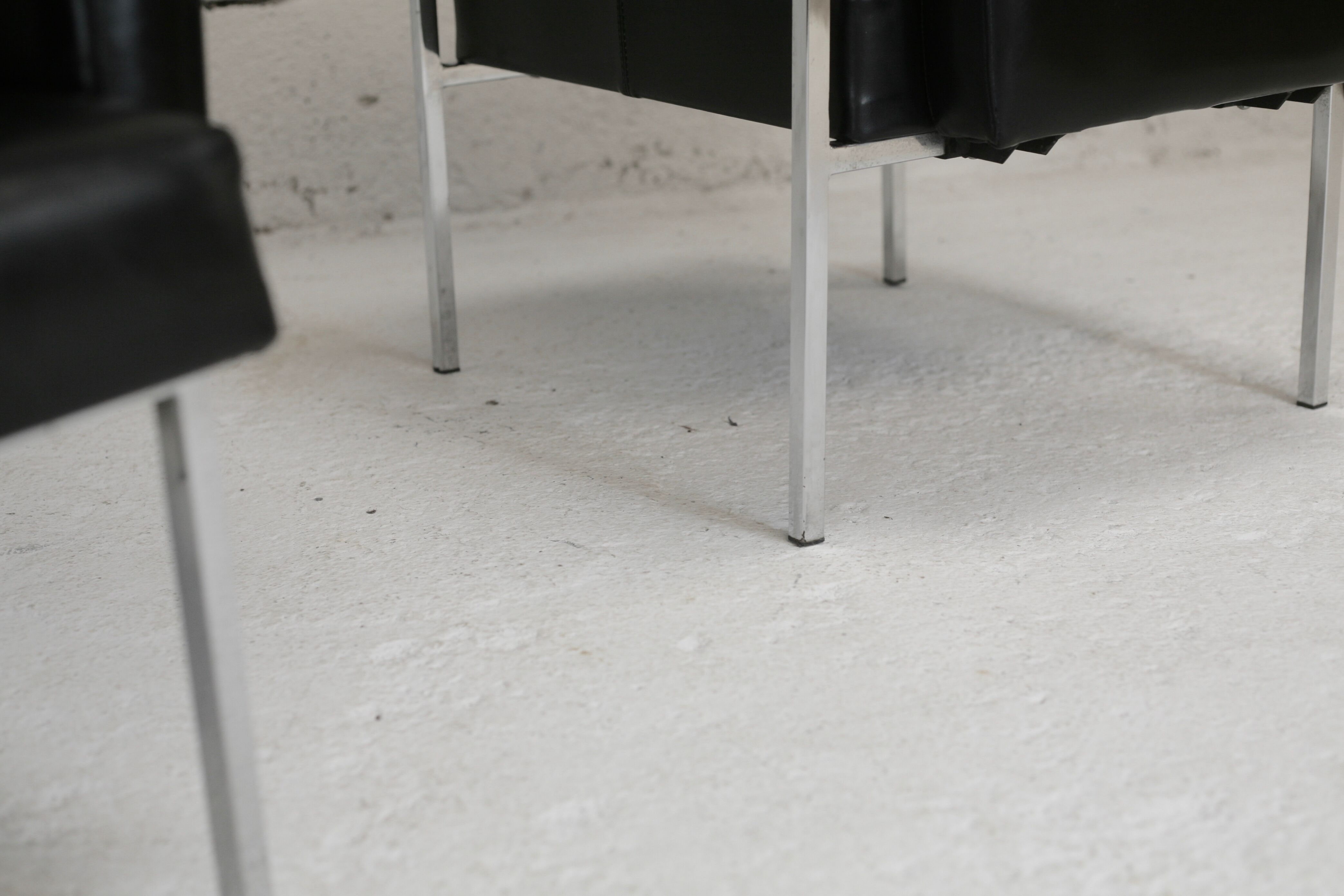 Pair of stainless steel, black leather-like armchairs, France, circa 1970