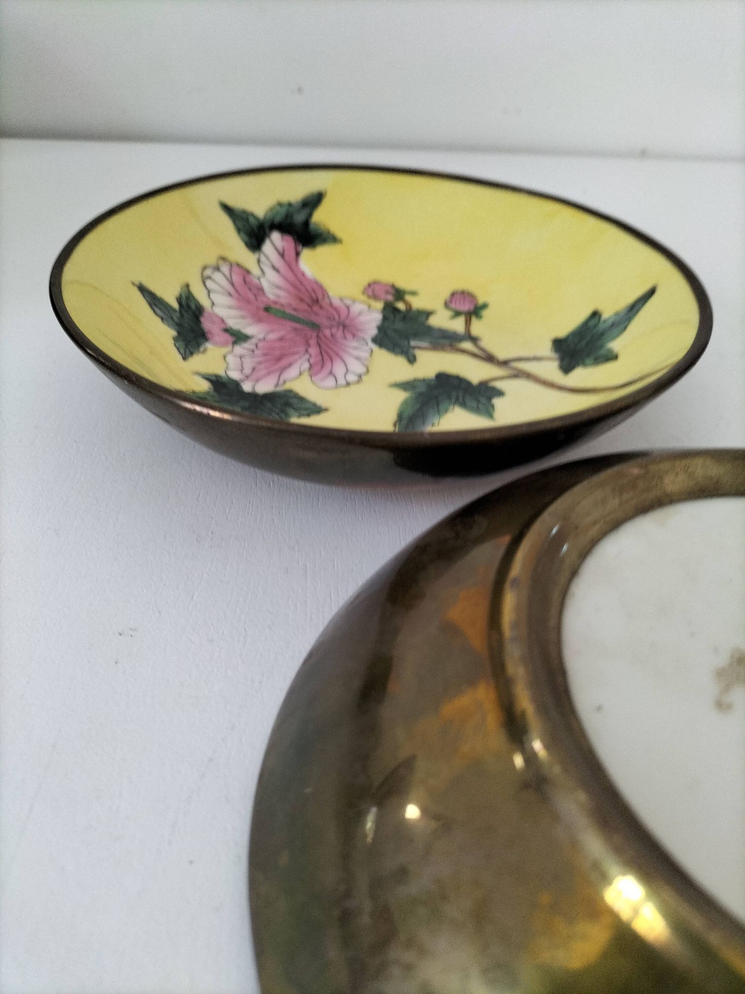 A pair of vintage Chinese decorative plates with floral designs on a yellow background.