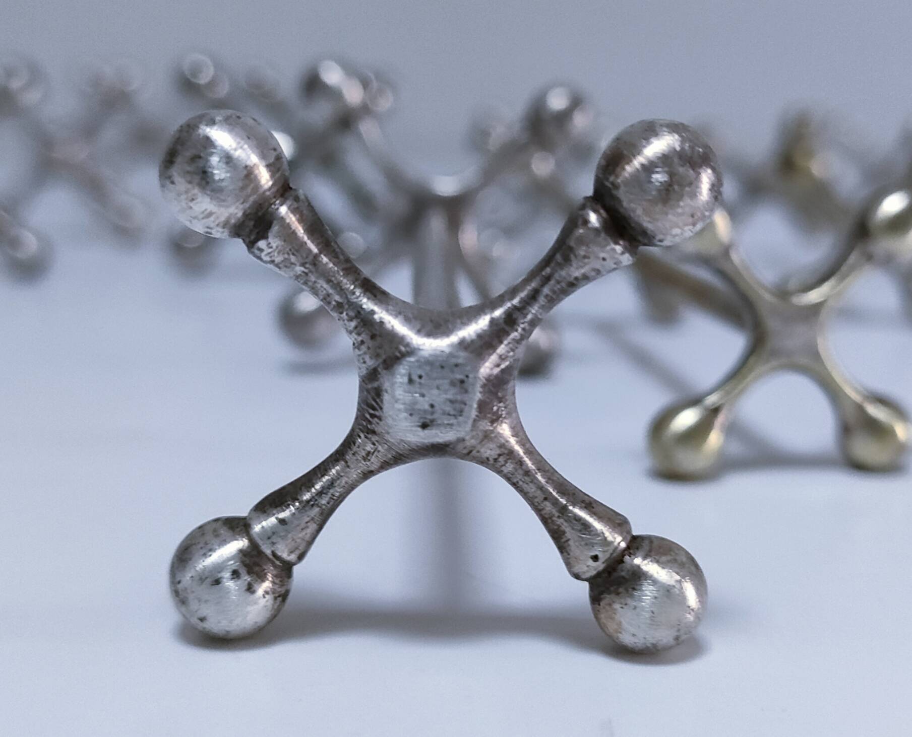 Eleven 70s design metal "crosshair" knife holders