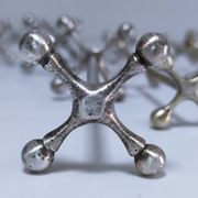 Eleven 70s design metal "crosshair" knife holders