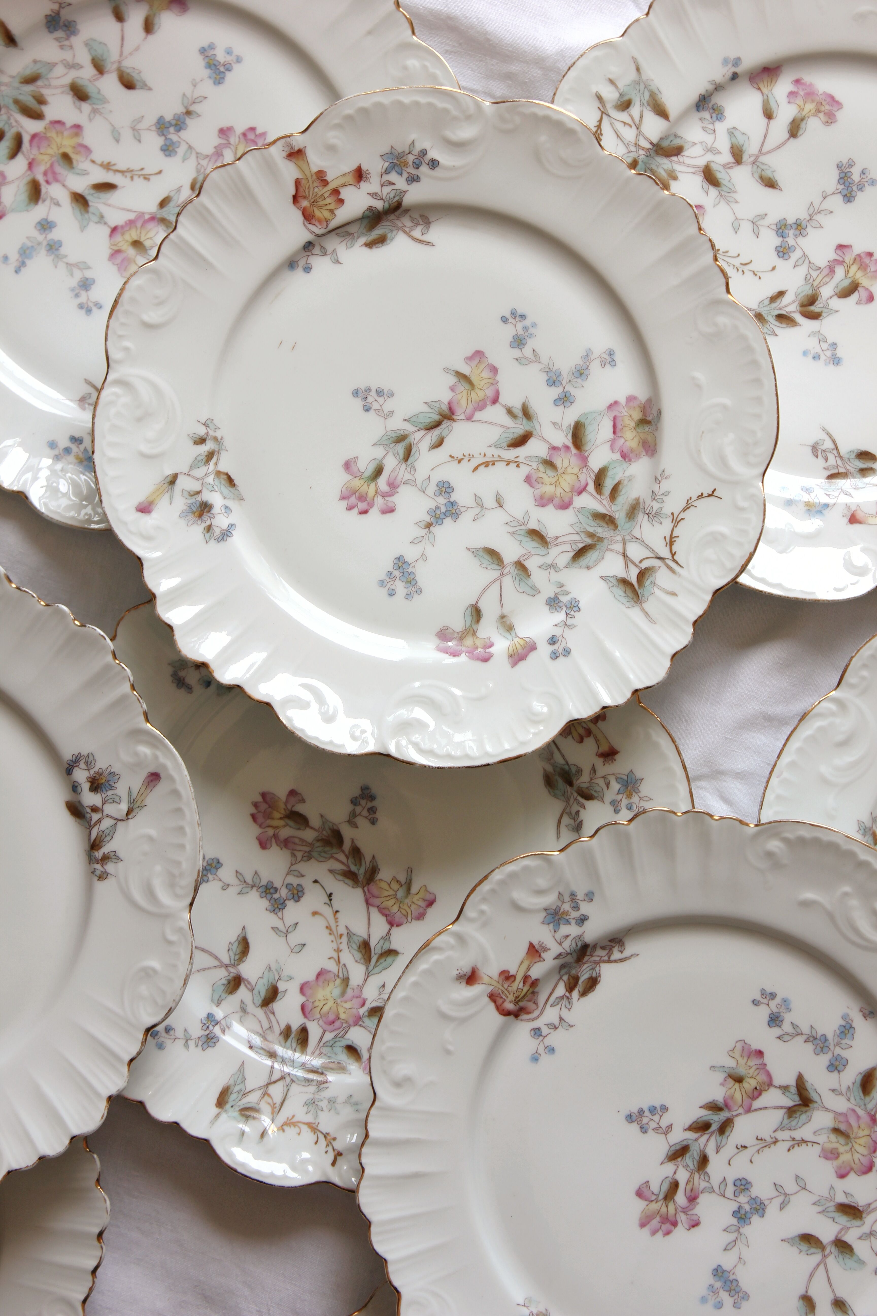 12 assiettes à dessert en porcelaine ancienne décor polychrome floral début XXe
