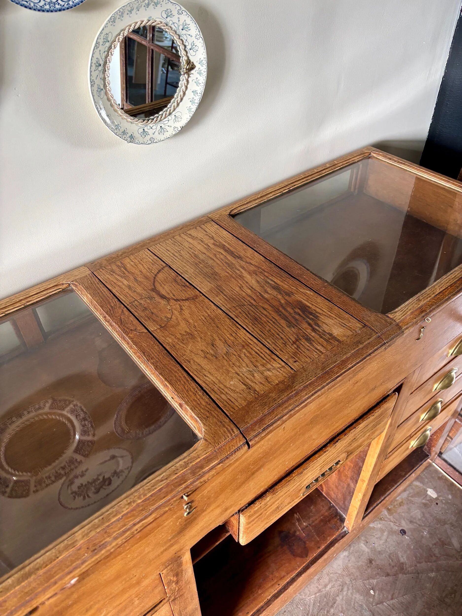Counter, glass-fronted wooden workbench in dark wood, 8 drawers.