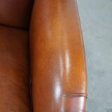 Cognac-colored sheepskin armchair with rounded shapes