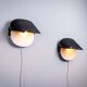 Matte black wall lamps with perforated shades and brass details