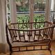 Wooden cradle in walnut with a sign collar at the top.