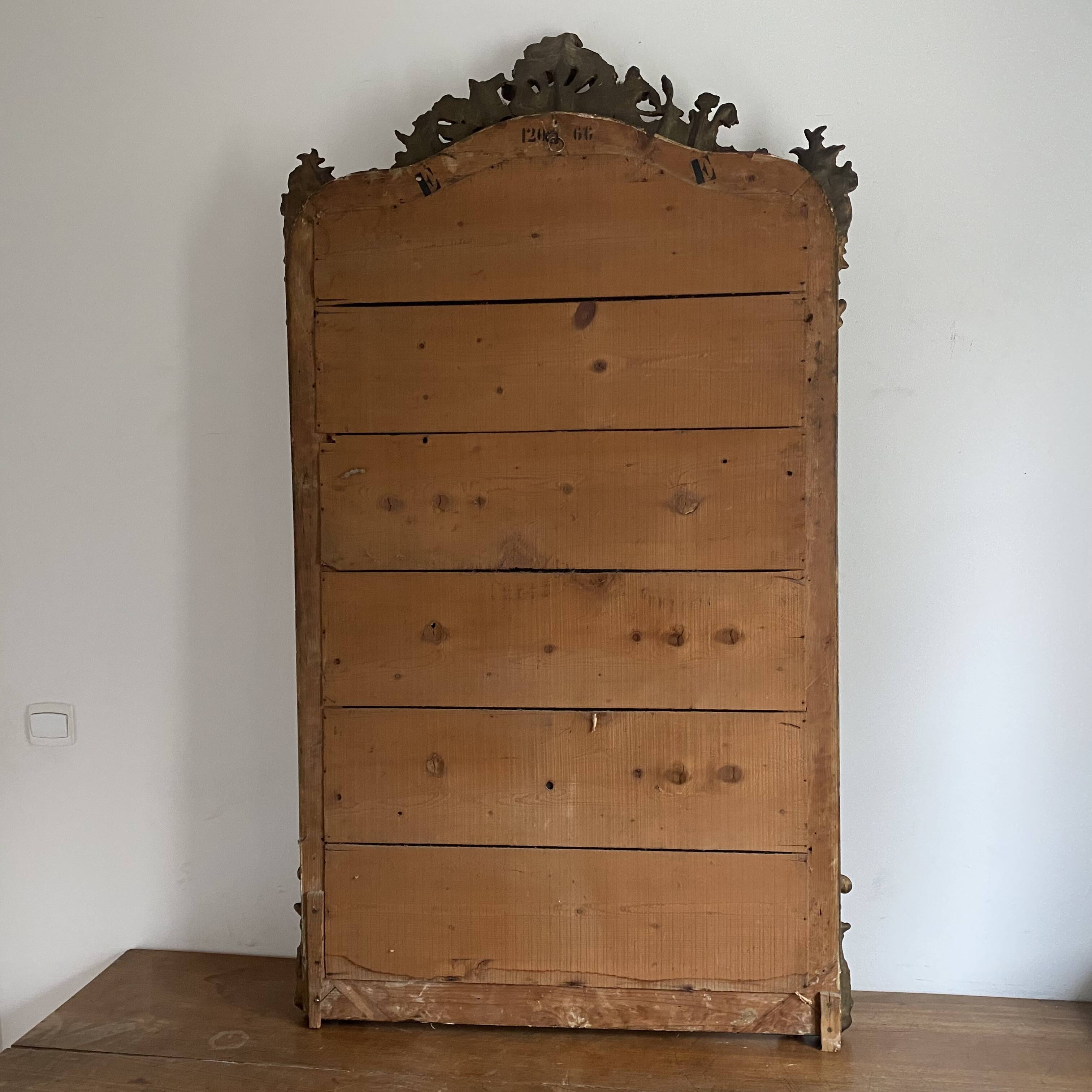 Late 19th century gilded mirror with decorated pediment. 155x88.