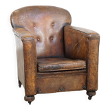 Fauteuil ancien en cuir de mouton sur roulettes et patiné