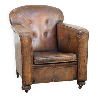 Antique sheepskin leather armchair on wheels and with patina