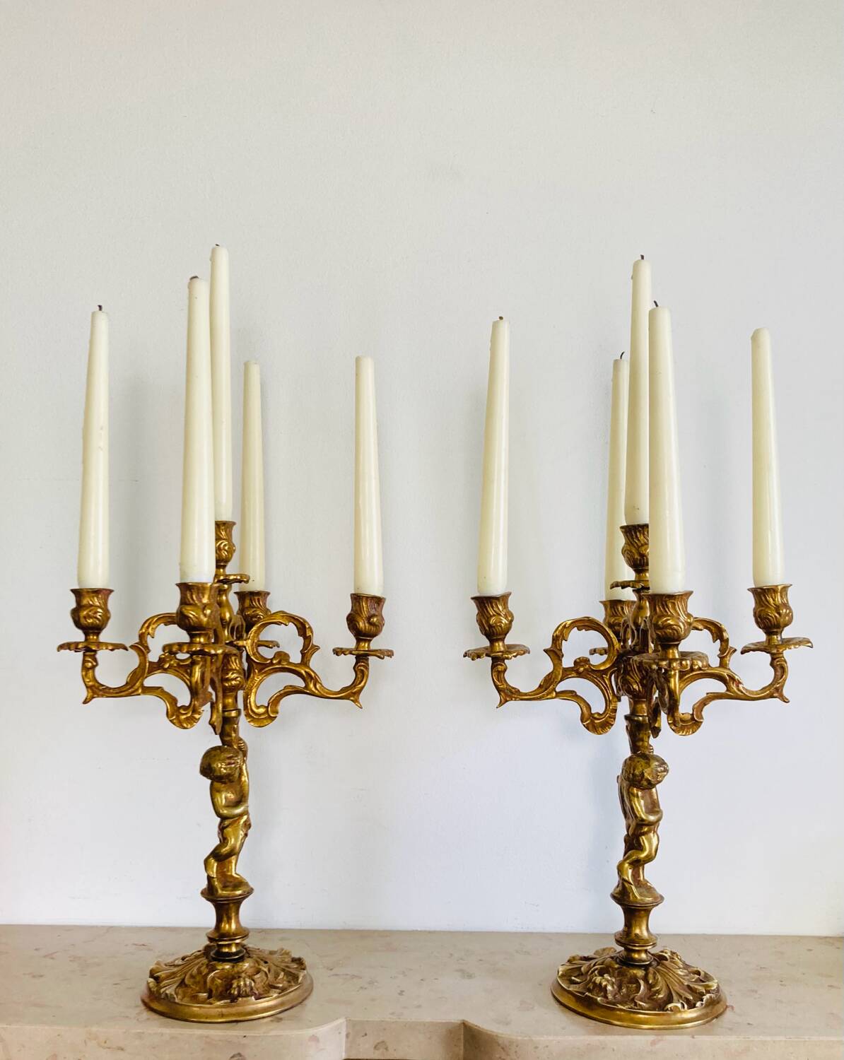 Solid bronze candlesticks decorated with putti, acanthus leaves and lion heads