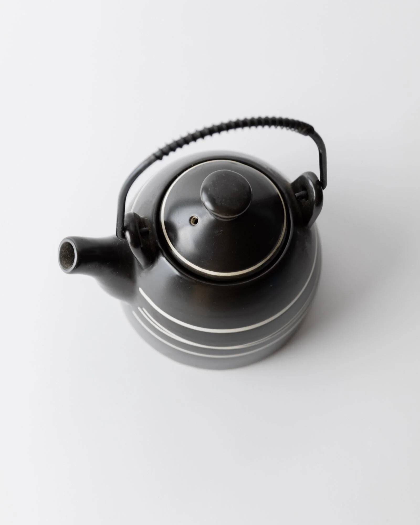 Vintage ceramic teapot from the 1980s, black with white stripes and a metal handle.