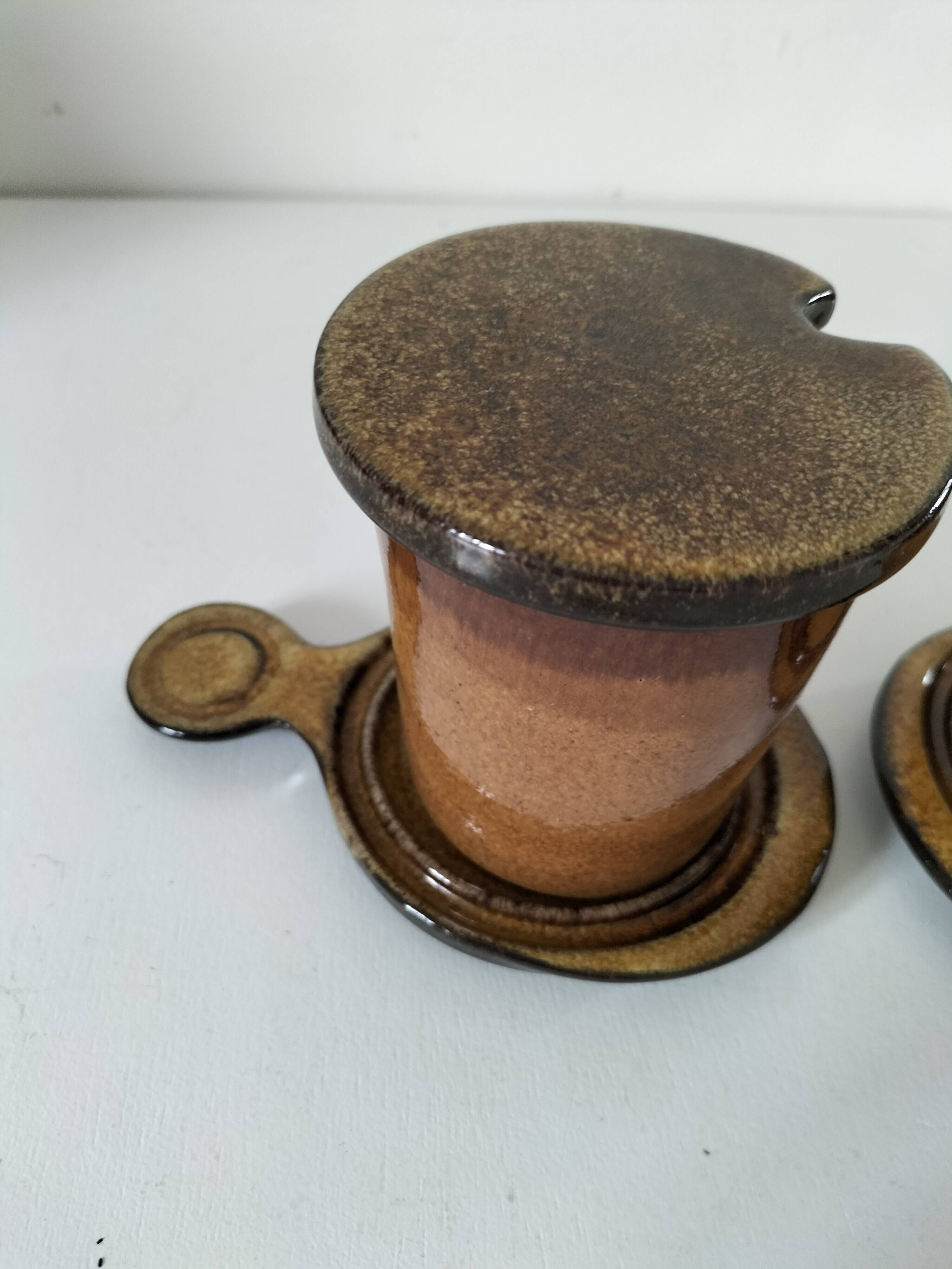 Pair of glazed stoneware cups with saucers and lids