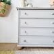 Commode ancienne à 4 tiroirs en bois peint gris perle patiné et pieds boules