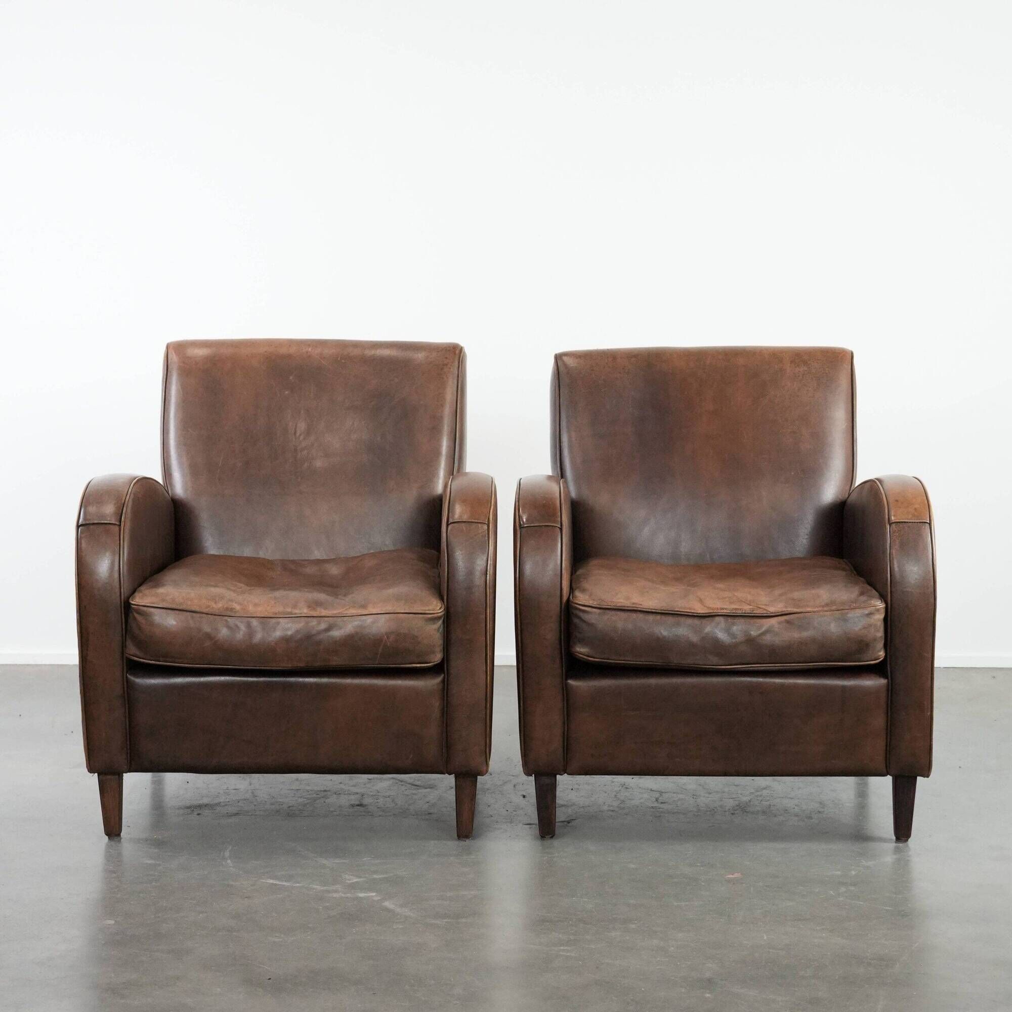 Elegant set of two sheepskin leather armchairs with beautiful round shapes