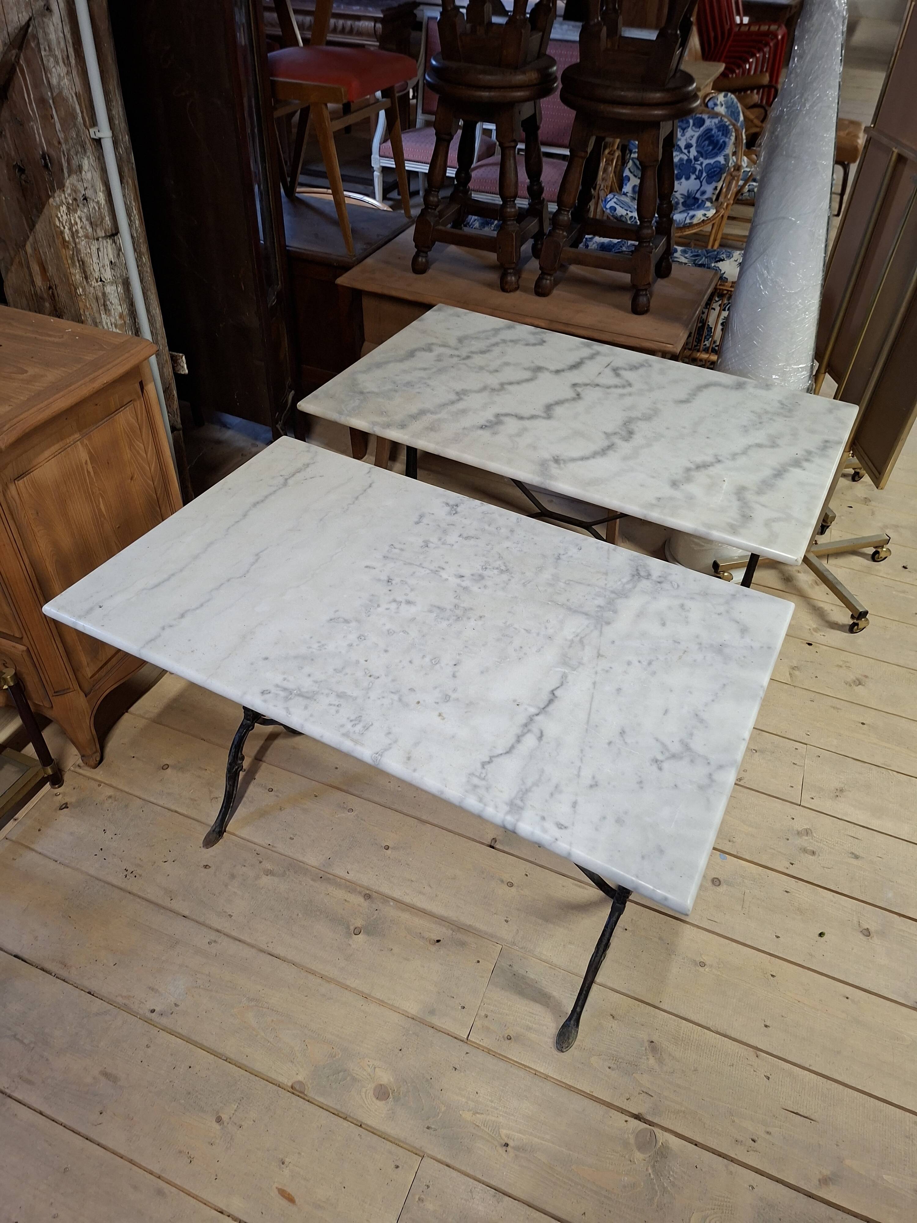 Pair of bistro tables in marble and cast iron.
