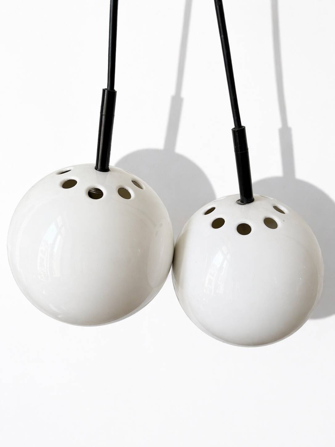 Two white metal globe pendant lights, 1970s.