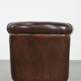Dark brown vintage club armchair in English style made of sheepskin leather