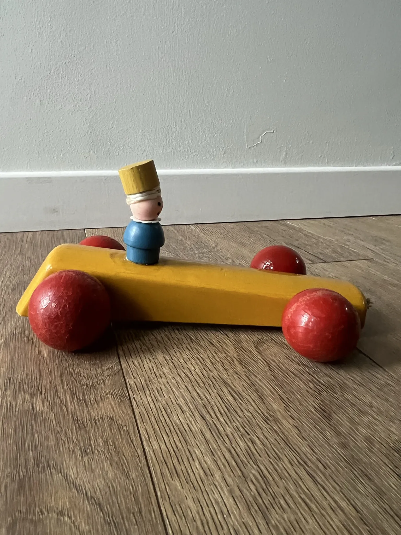 Vintage wooden pull toy, yellow car and small soldier.