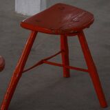 Pair of patinated wooden stools painted red with flared legs, 1950s-1960s.
