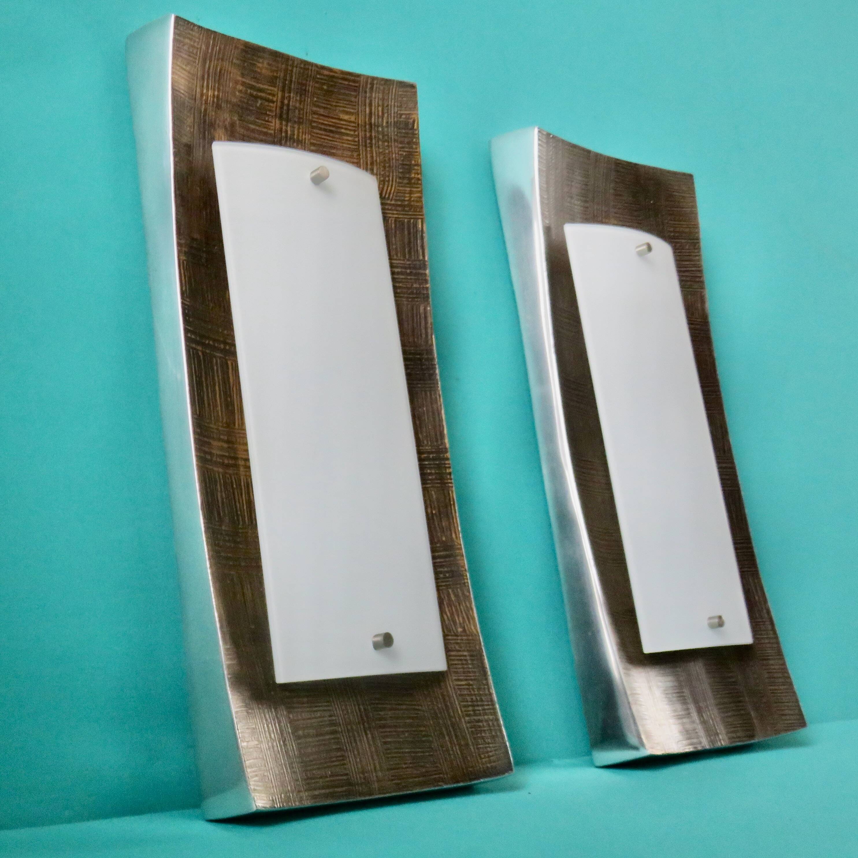 Pair of wall sconces in gold-plated alloy with bas-relief and opaline glass. Germany, 1980