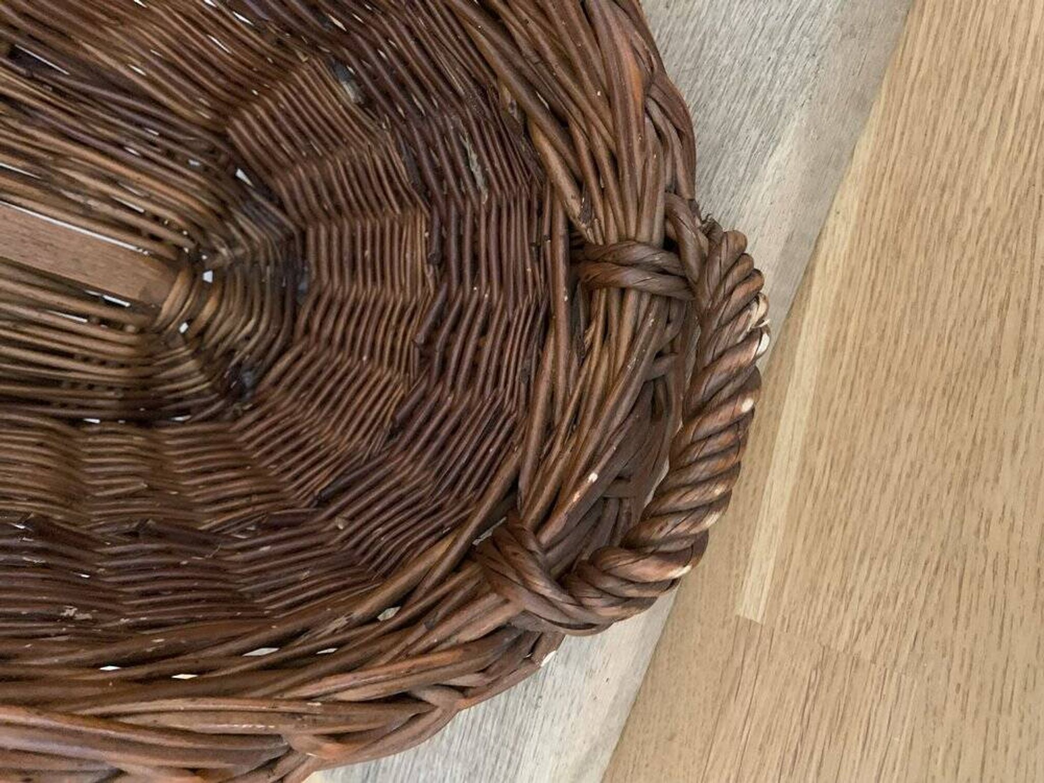 Vintage brown wicker baguette basket, elongated shape, with integrated handles.