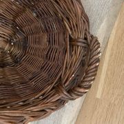 Vintage brown wicker baguette basket, elongated shape, with integrated handles.