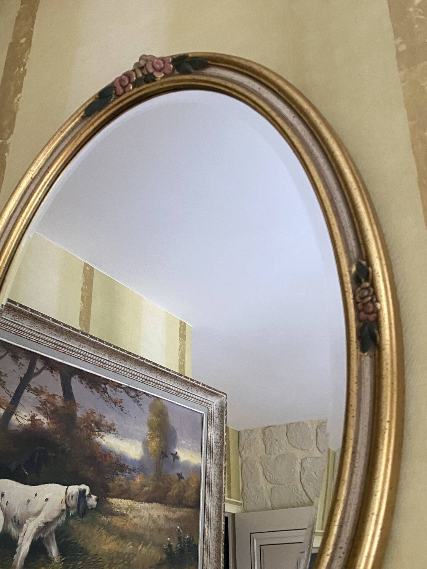 Oval wooden frame with floral decoration in gold.