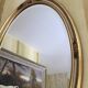 Oval wooden frame with floral decoration in gold.