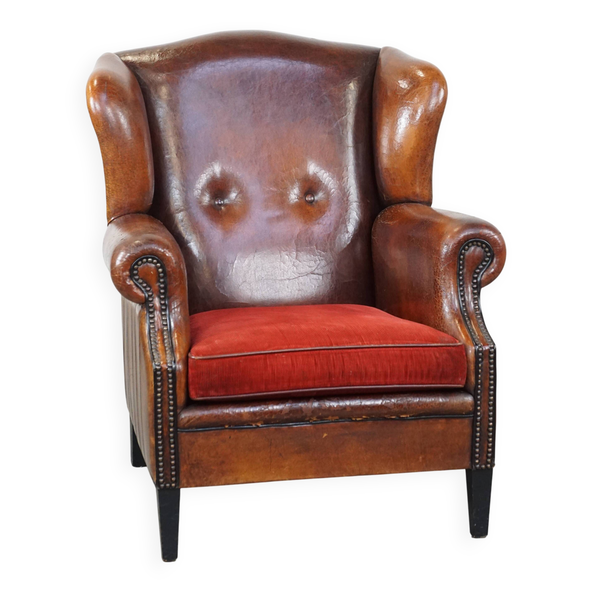Sheepskin leather wingback chair with a red corduroy seat cushion
