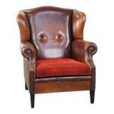 Sheepskin leather wingback chair with a red corduroy seat cushion