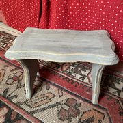 Small footrest bench in solid wood with a slate grey patina.