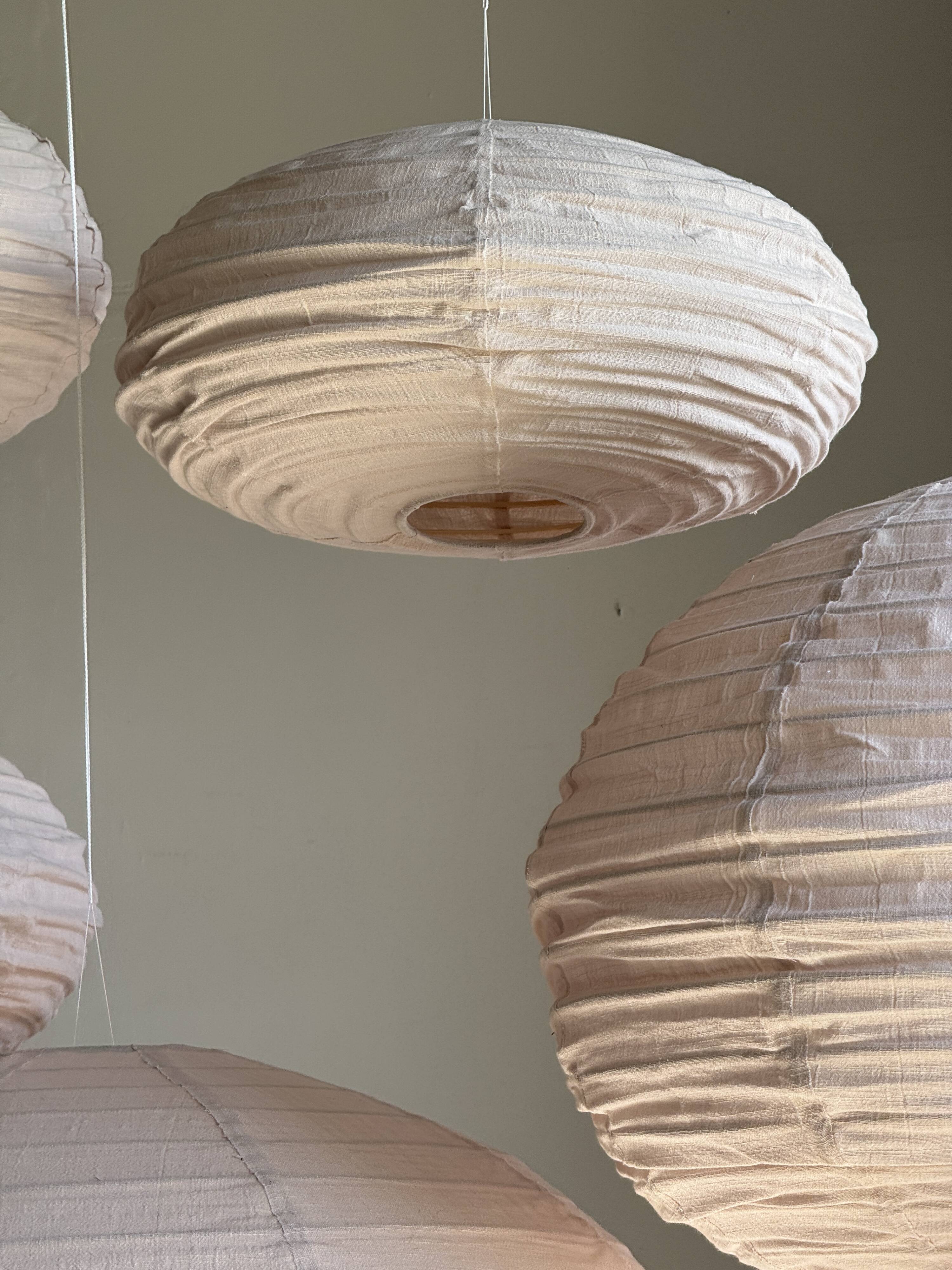 Average suspension in natural rattan and linen, Japanese-style, flattened oval in pink.