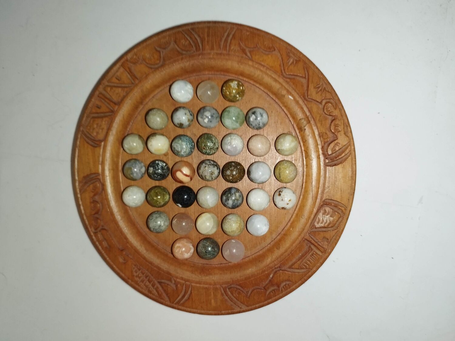Ancient solitaire game in wood and stone marbles