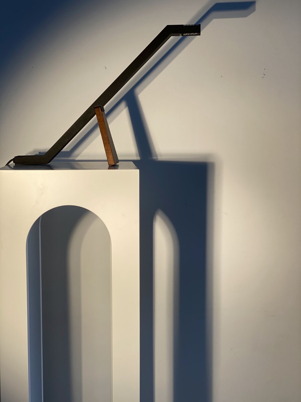 Black solid monoxyl wood bench carved into 3 arches