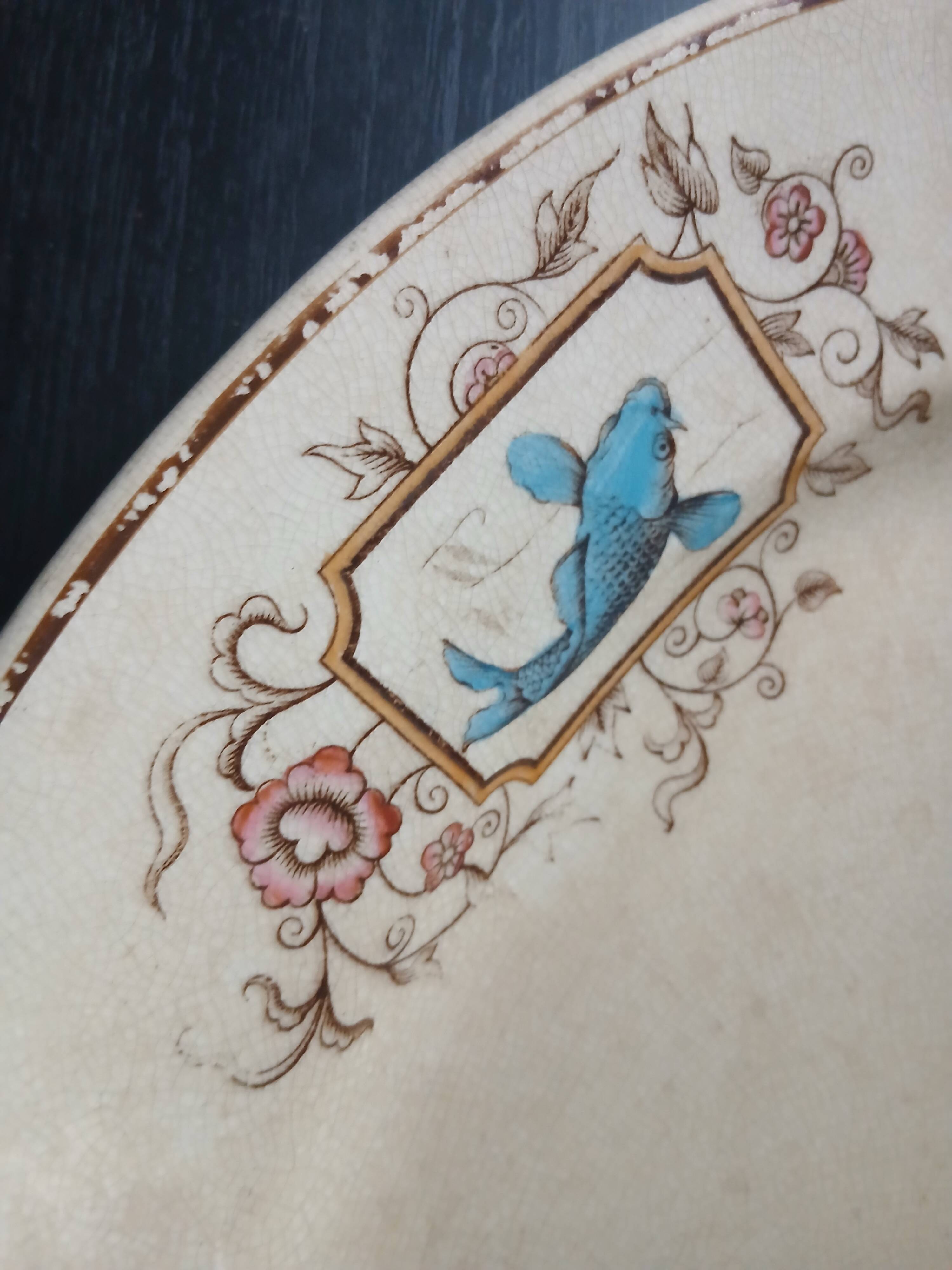Large antique plate stamped with a fauna and flora pattern.