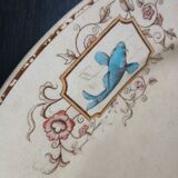 Large antique plate stamped with a fauna and flora pattern.