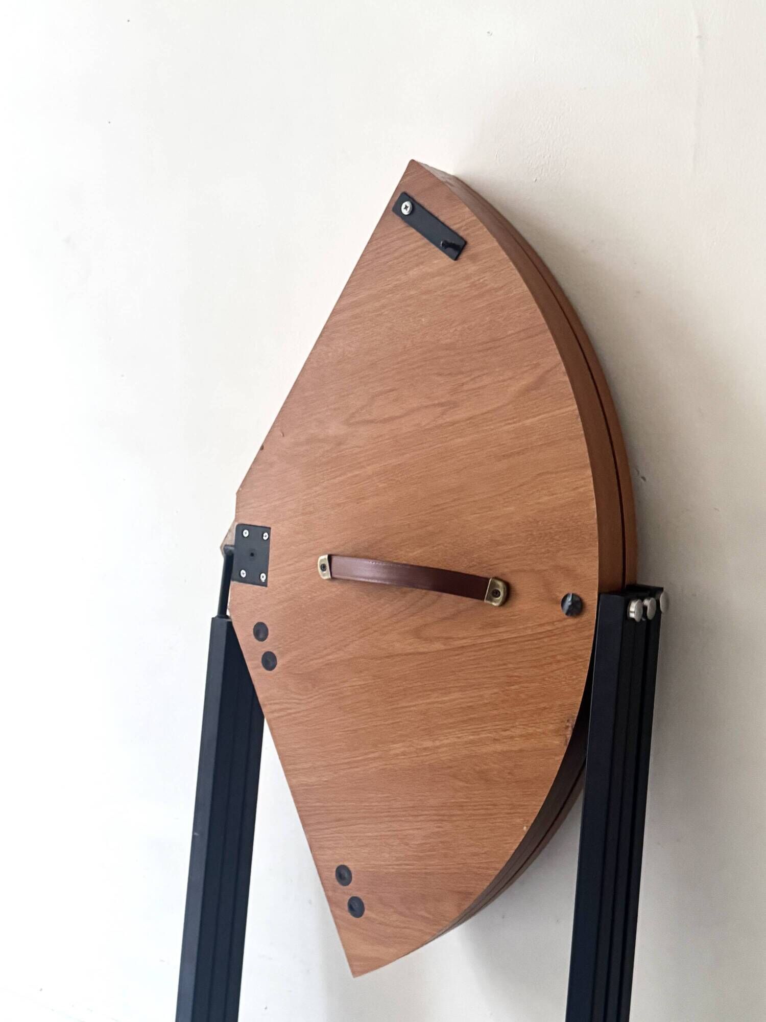 Modernist round folding dining table in wood and metal.