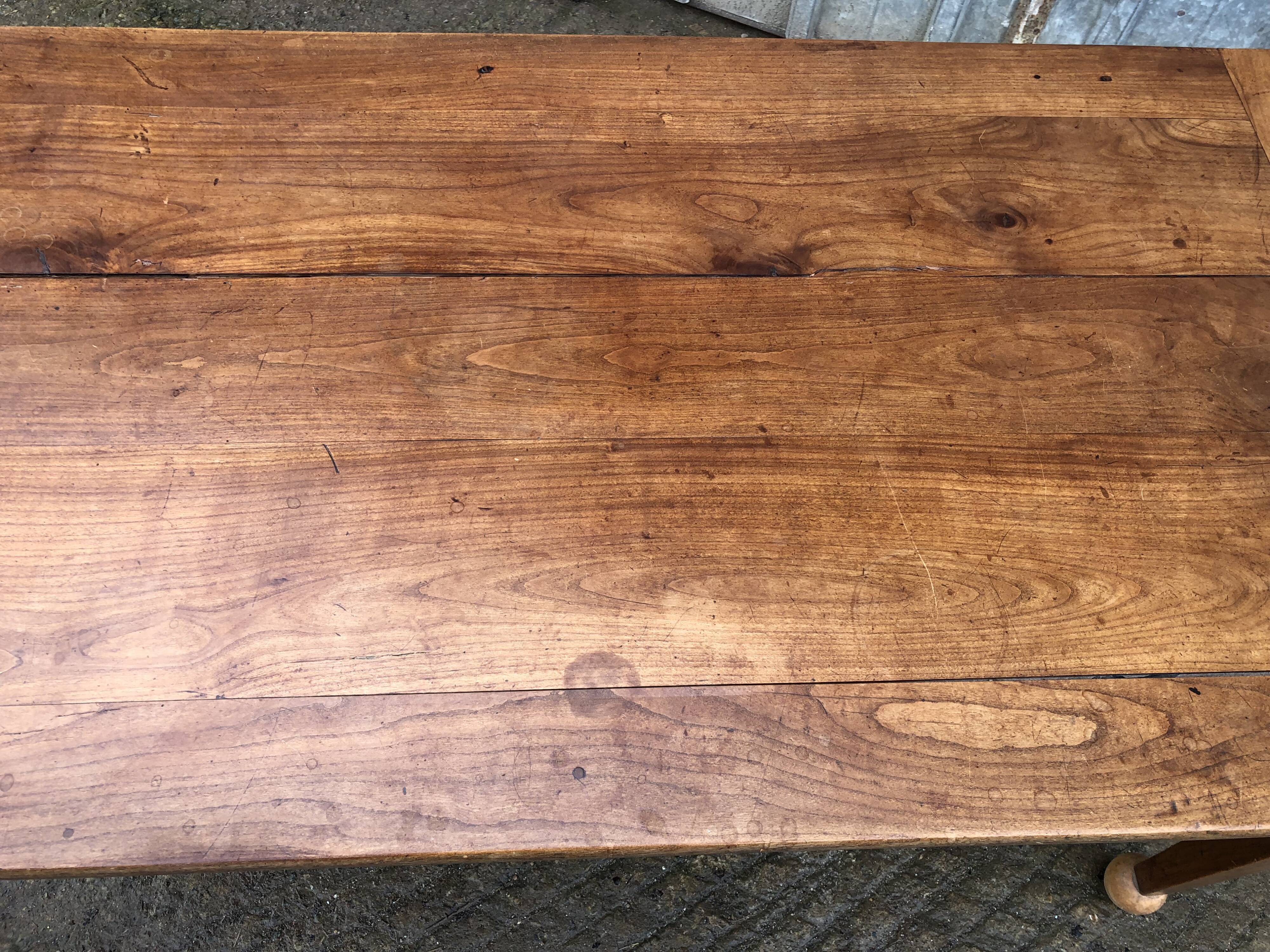 Antique solid cherry farmhouse table with 2 end drawers and 1 pull-out.