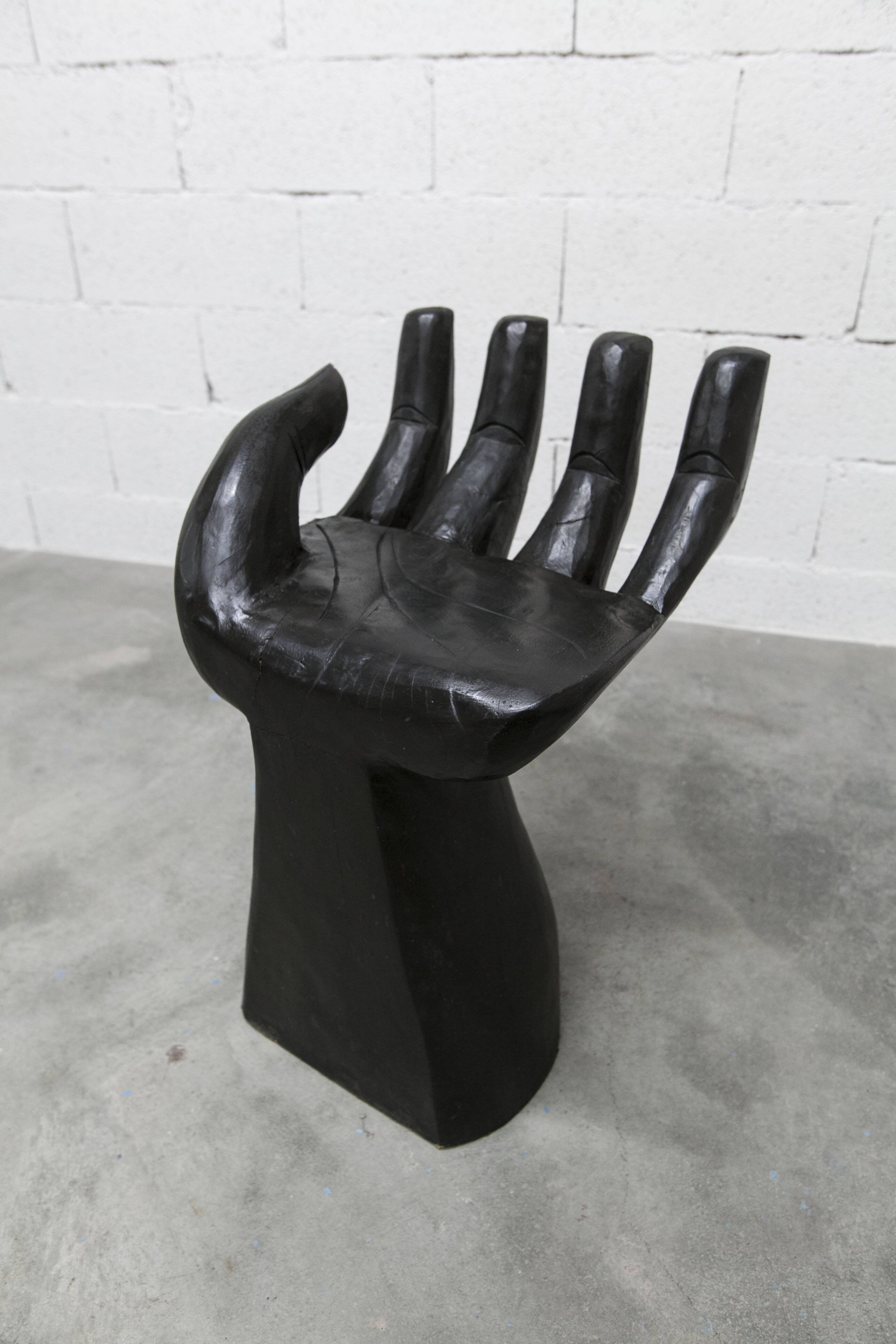 Black armchair chair in carved wood in the shape of a hand