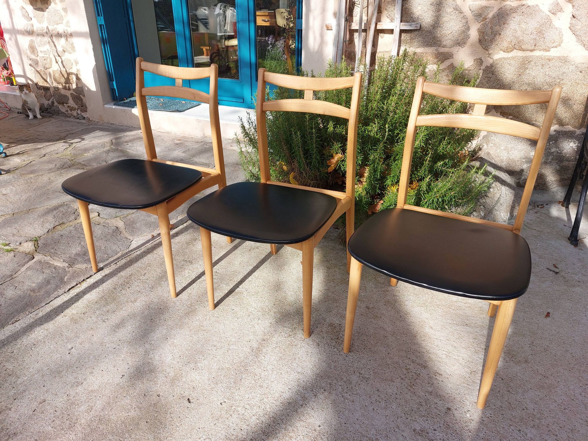 3 Scandinavian style chairs, light wood and black faux leather.
