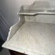 Antique wood and marble kitchen sideboard with carved backsplash