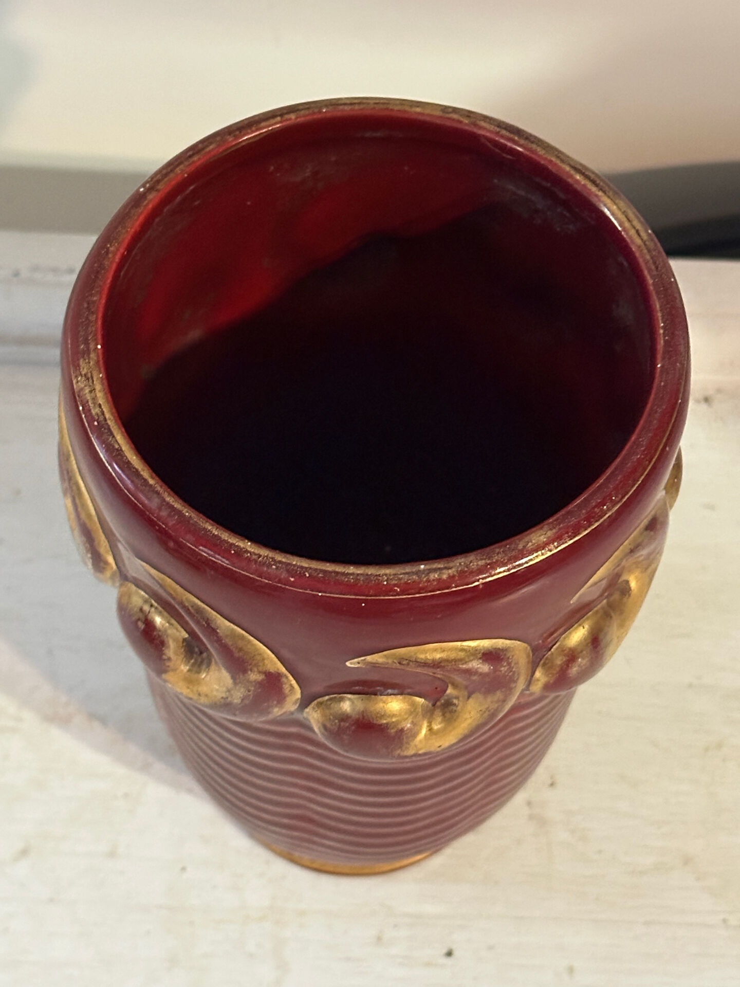 Mid-century relief vase in ruby red enhanced with gilding.
