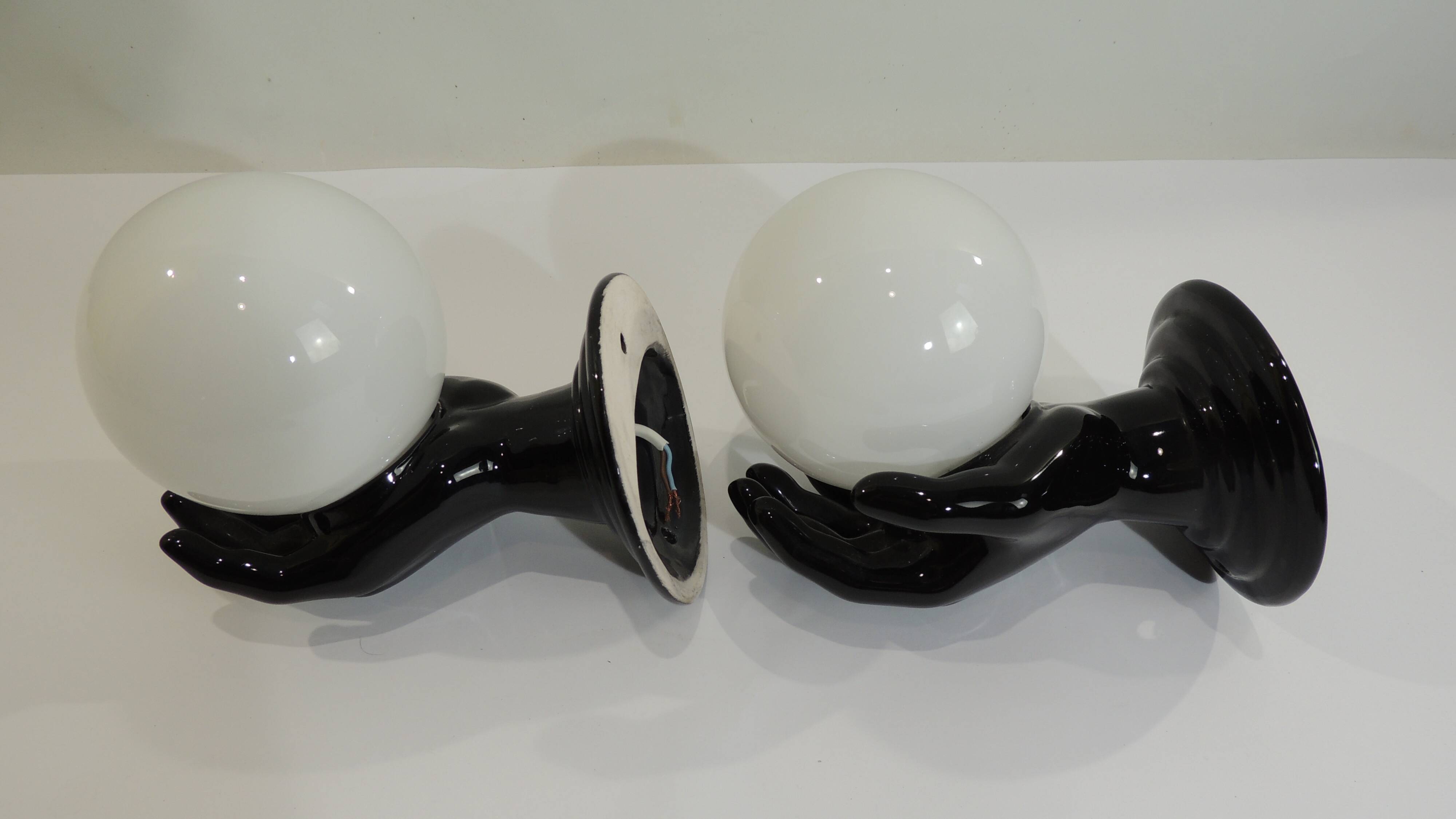 Paire d’appliques mains noires tenant un globe en opaline, années 70