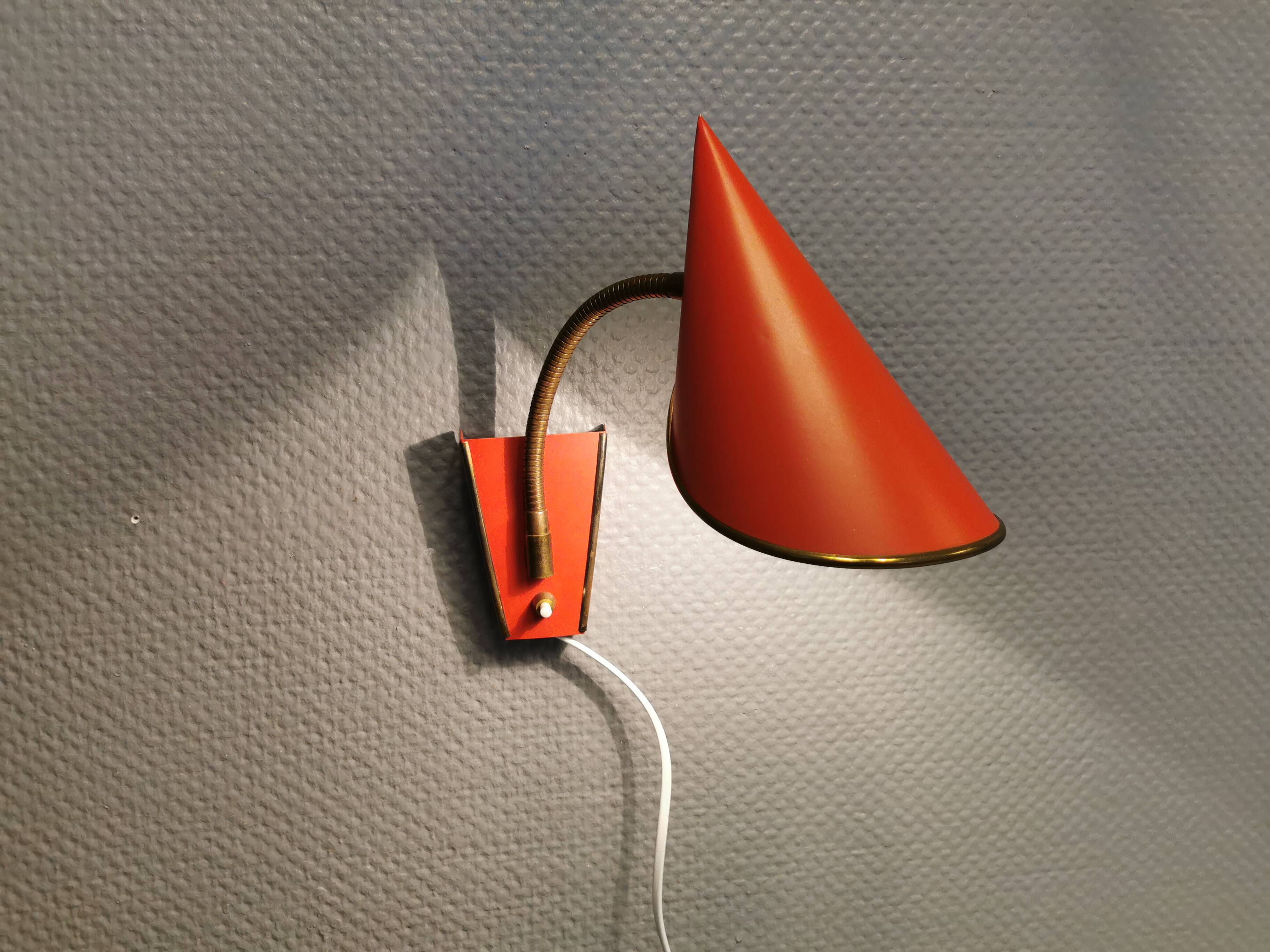 Danish red lacquered wall light with brass details. Estimated 1980s