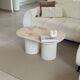 Oval coffee table in travertine and white fluted wood.