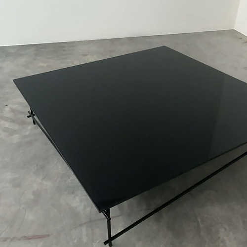 Minimalist black glass coffee table with industrial metal base