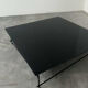 Minimalist black glass coffee table with industrial metal base