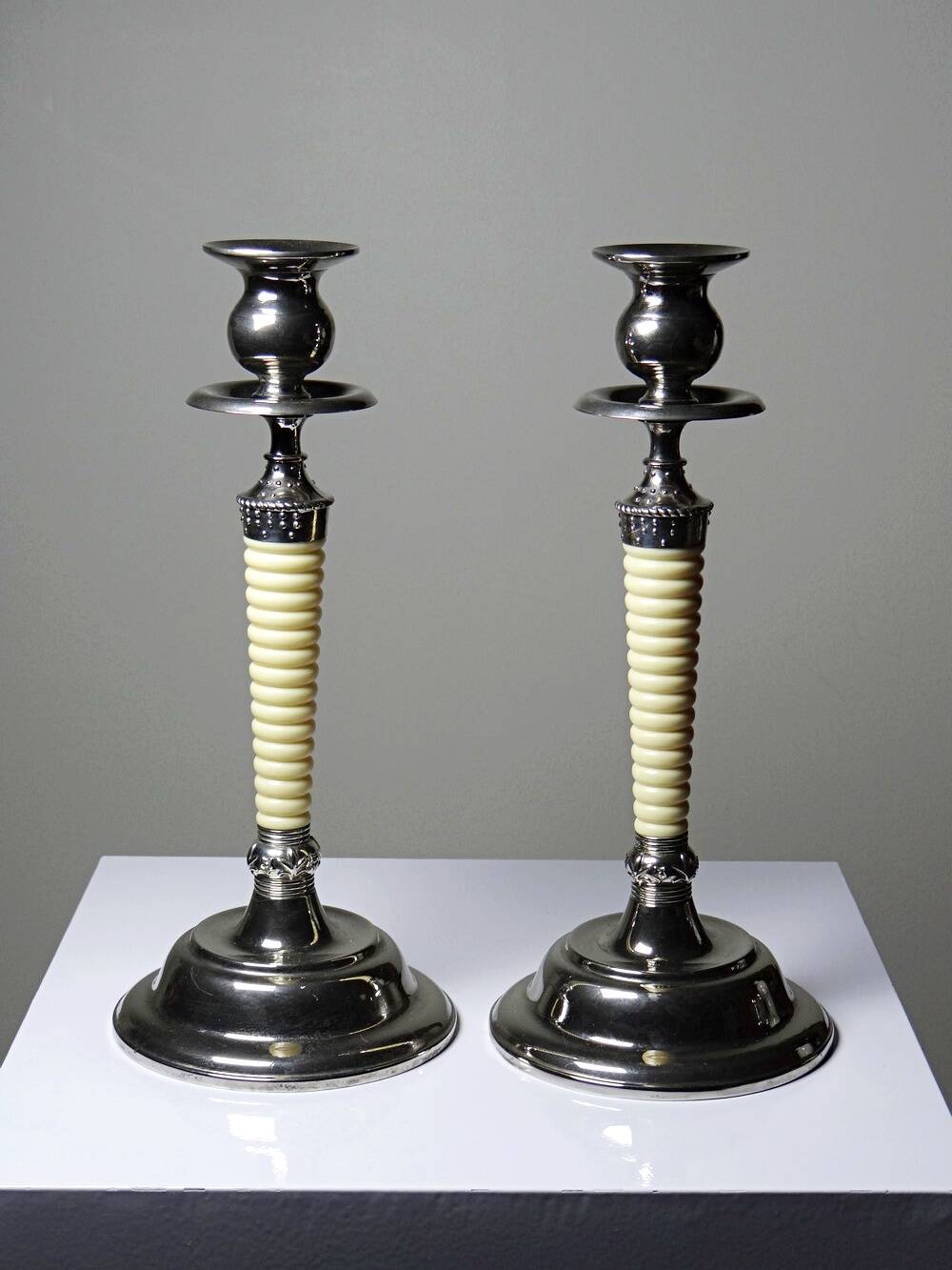 Pair of vintage candlestick holders in silver-plated metal with ivory-style plastic.