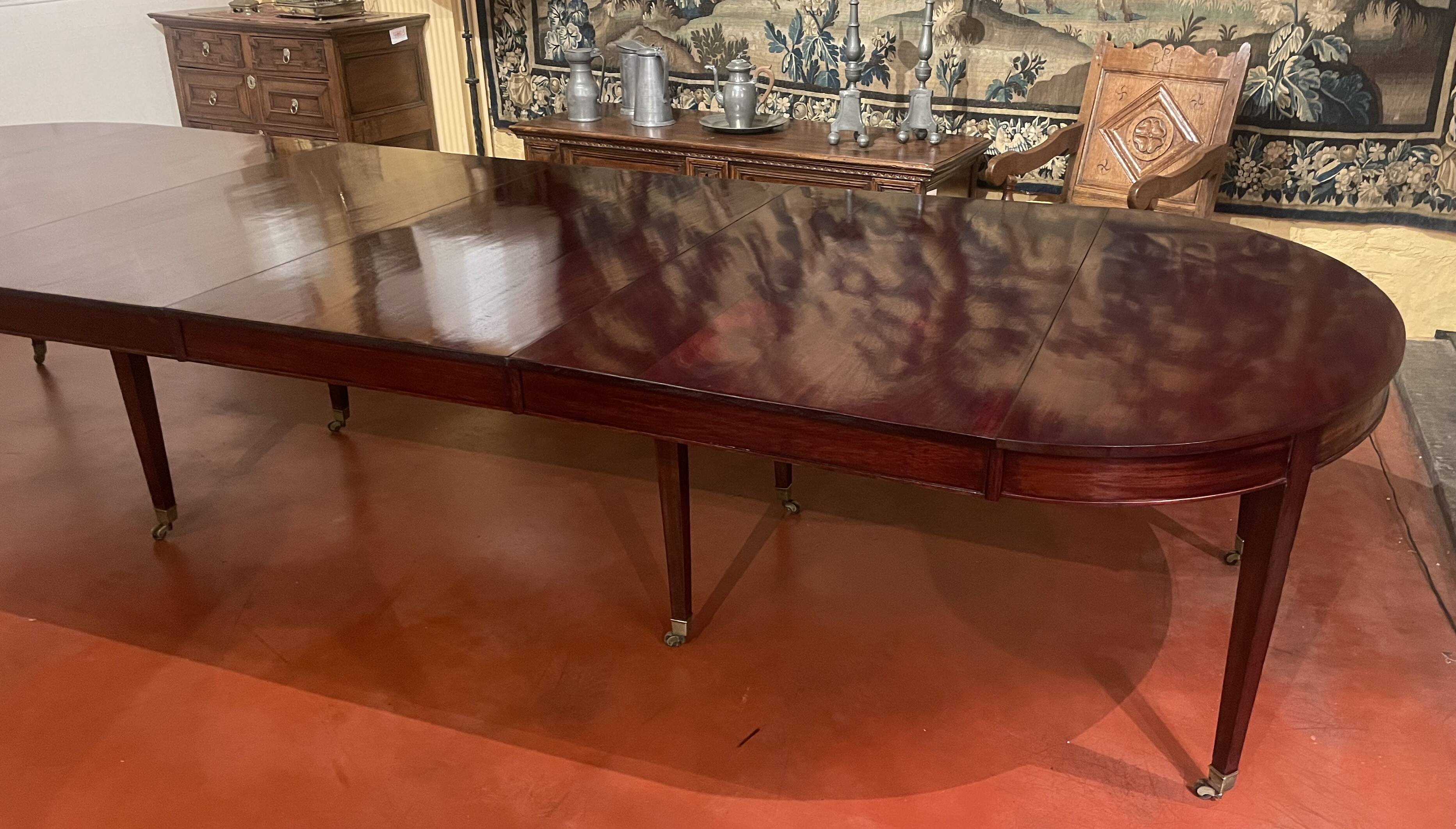 Directoire period extendable dining table in mahogany with a band.